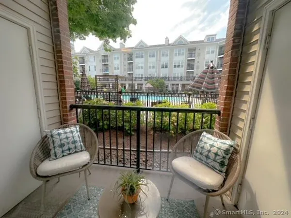 a kitchen with stainless steel appliances kitchen island granite countertop a table chairs in it and wooden floors
