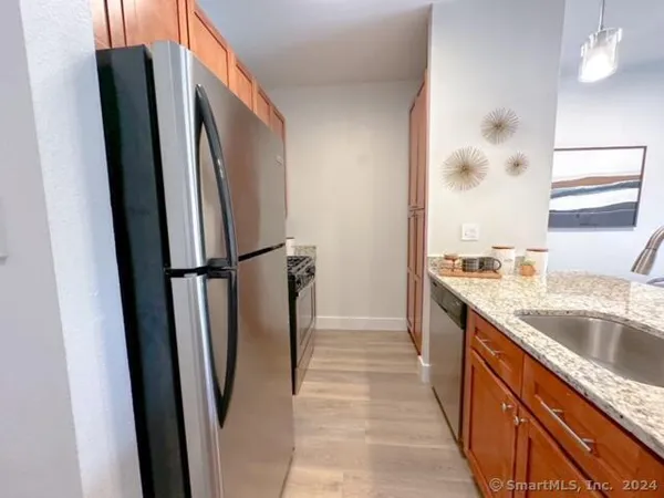 a kitchen with stainless steel appliances granite countertop a refrigerator and a sink
