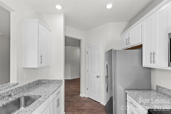 a kitchen with stainless steel appliances granite countertop a refrigerator and a sink