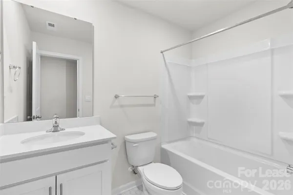a white toilet sitting next to a white sink and vanity