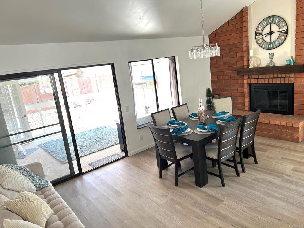 3594 Newland Road Oceanside, CA 92056 - Photo 16 of 44 a view of a dining room with furniture a chandelier and wooden floor