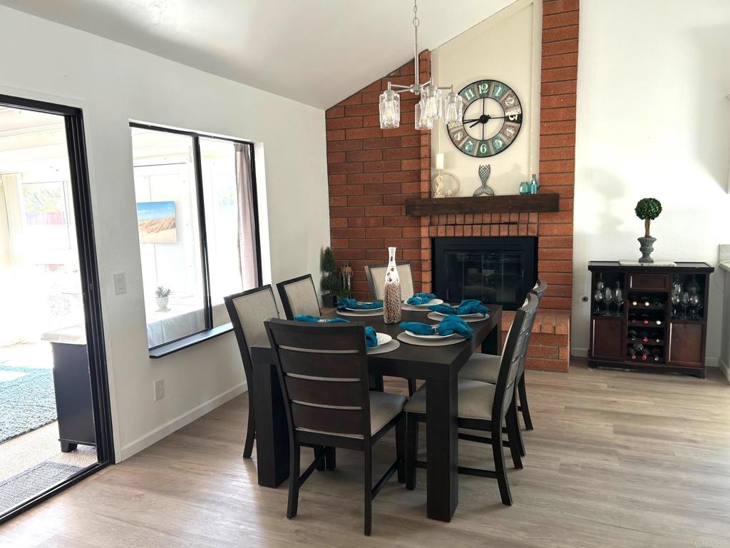 3594 Newland Road Oceanside, CA 92056 - Photo 17 of 44 a dining room with furniture a fireplace and wooden floor