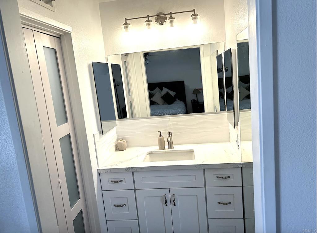 3594 Newland Road Oceanside, CA 92056 - Photo 29 of 44 a bathroom with a double vanity sink and a mirror