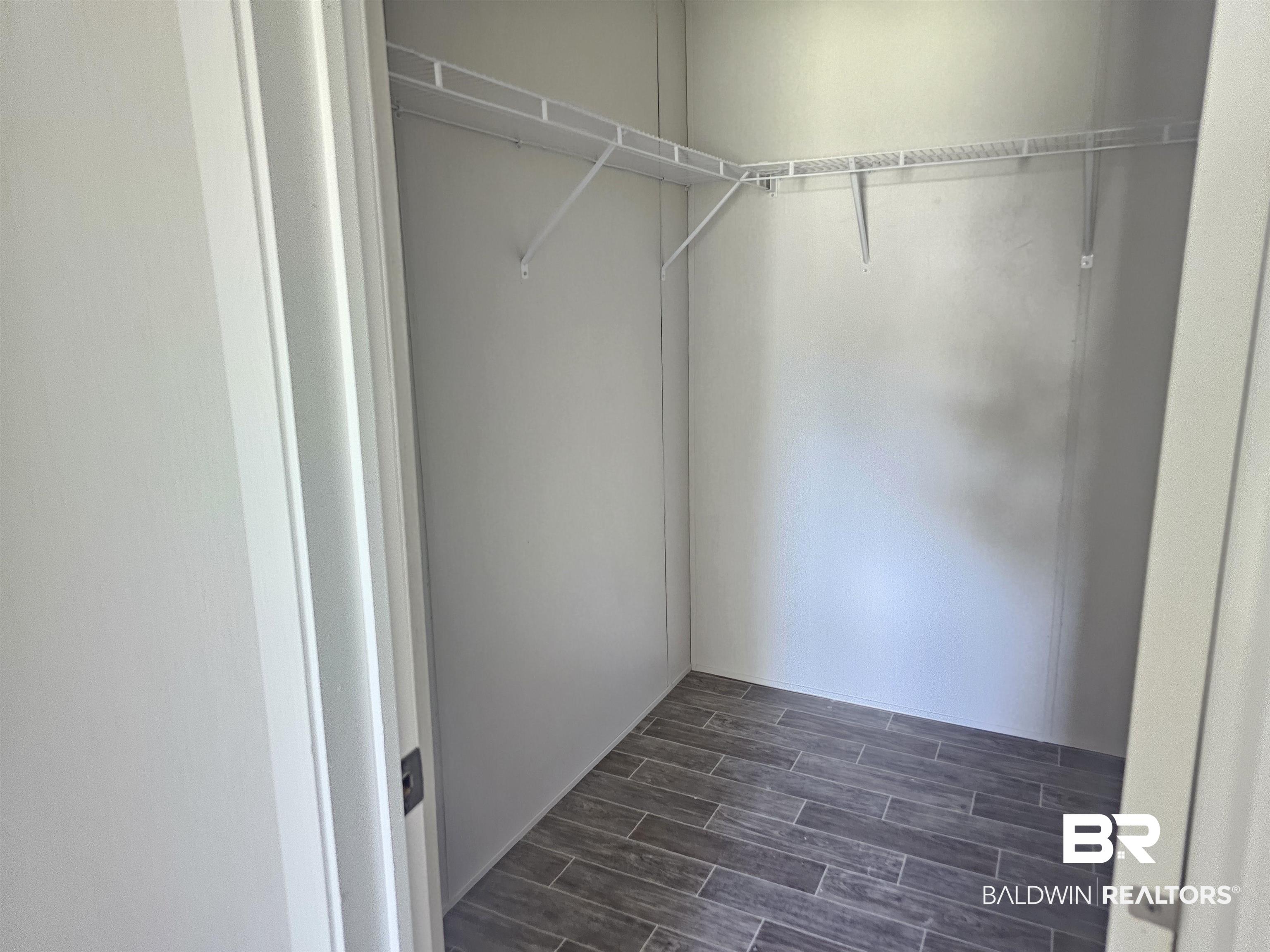 1863 Wait Road Monroeville, AL 36460 - Photo 17 of 38 Walk in closet with dark hardwood / wood-style flooring
