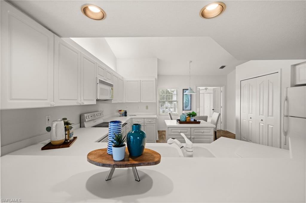 13100 Hamilton Harbour Drive, Unit G11 Naples, FL 34110 - Photo 11 of 32 a kitchen with a sink and white appliances