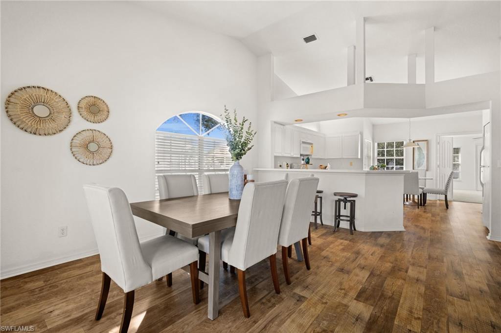 13100 Hamilton Harbour Drive, Unit G11 Naples, FL 34110 - Photo 9 of 32 a view of a dining room with furniture and wooden floor