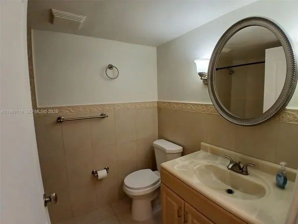a bathroom with a sink mirror and toilet