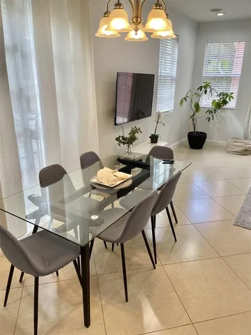 a view of a dining room with furniture and a potted plant