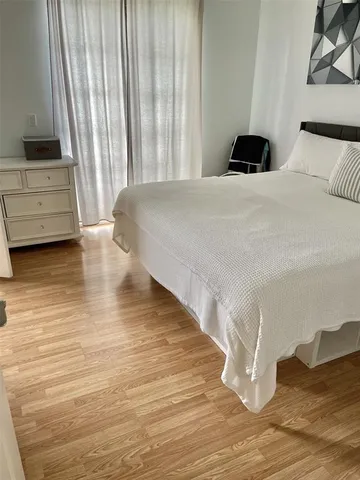 a bedroom with a bed and a flat tv screen on a dresser
