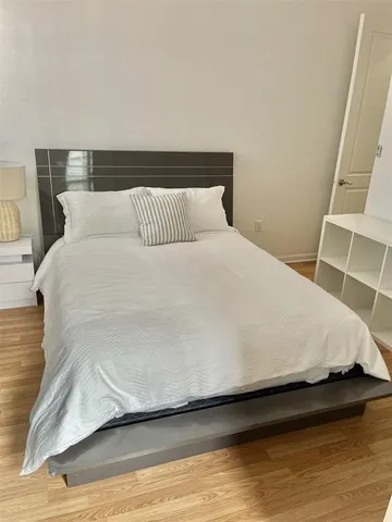 a large bed sitting in a bedroom next to a window