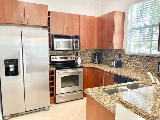 a kitchen with granite countertop a refrigerator stove and microwave
