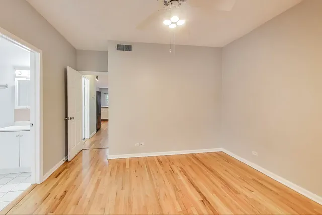 a view of a room with wooden floor and a hallway