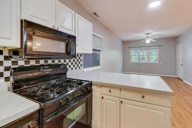 a kitchen with granite countertop a stove and a microwave