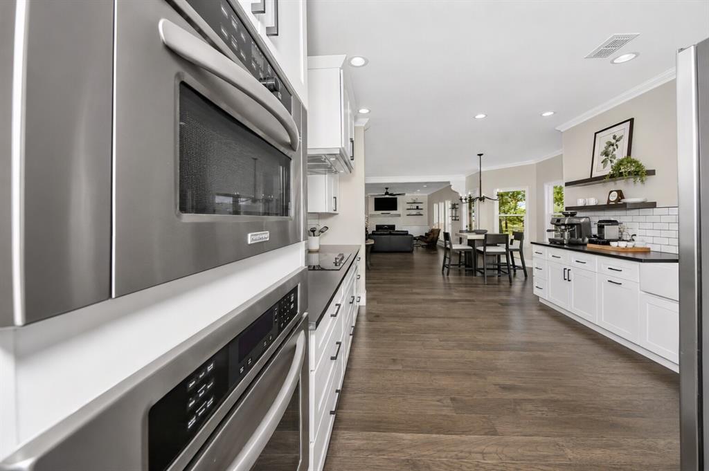 3817 Ganzer Road West Denton, TX 76207 - Photo 17 of 40 This angle shows the heart of the home — a clean, modern farmhouse kitchen that opens effortlessly into the dining nook and living room. Stainless appliances, quartz counters, and subway tile keep the kitchen feeling fresh, while the open layout makes everyday living easy. From morning coffee at the nook to movie nights in the living room, the space feels connected, bright, and designed for how people actually live today.