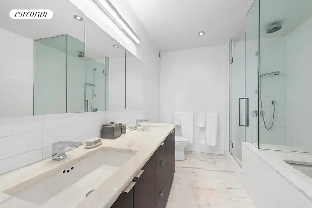 a bathroom with a double vanity sink mirror and shower