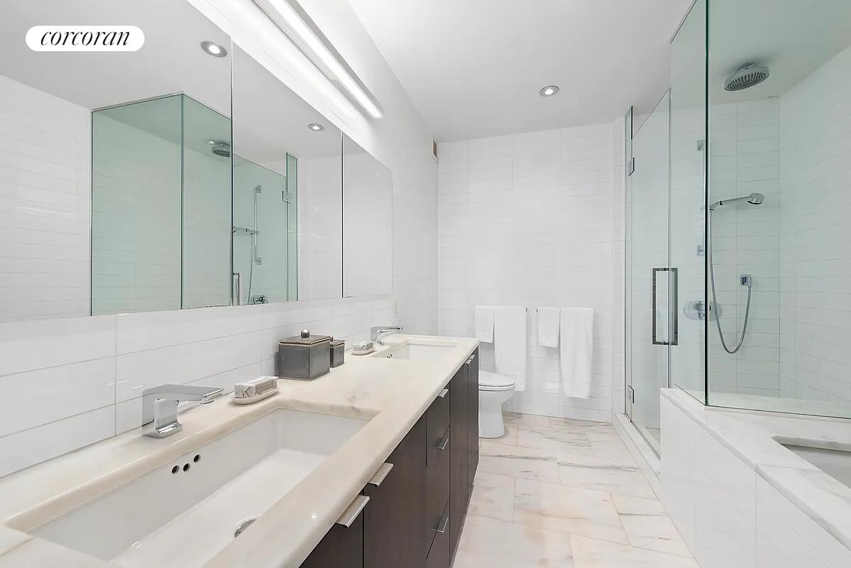 101 Warren Street, Unit 1450 Manhattan, NY 10007 - Photo 8 of 20 a bathroom with a double vanity sink mirror and shower