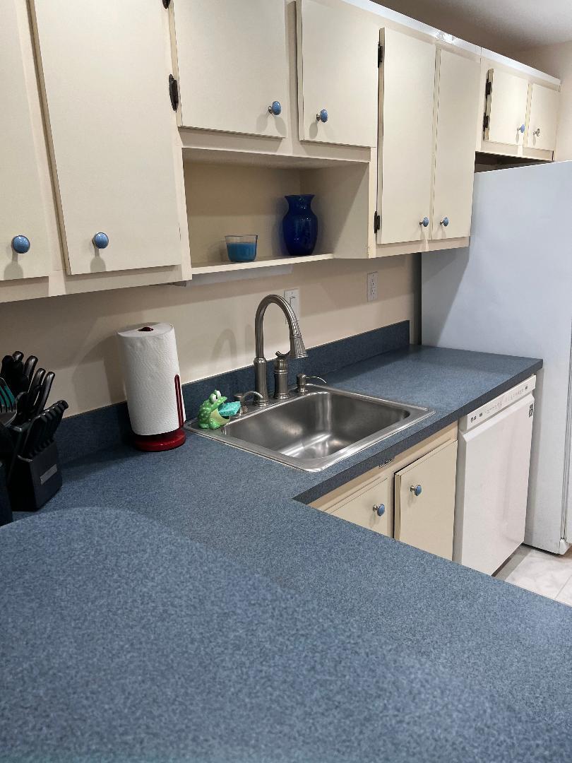 5403 Southeast Miles Grant Road, Unit 108 Stuart, FL 34997 - Photo 7 of 15 a kitchen with a sink and white cabinets