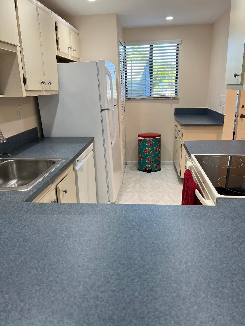 5403 Southeast Miles Grant Road, Unit 108 Stuart, FL 34997 - Photo 8 of 15 a kitchen with refrigerator and window