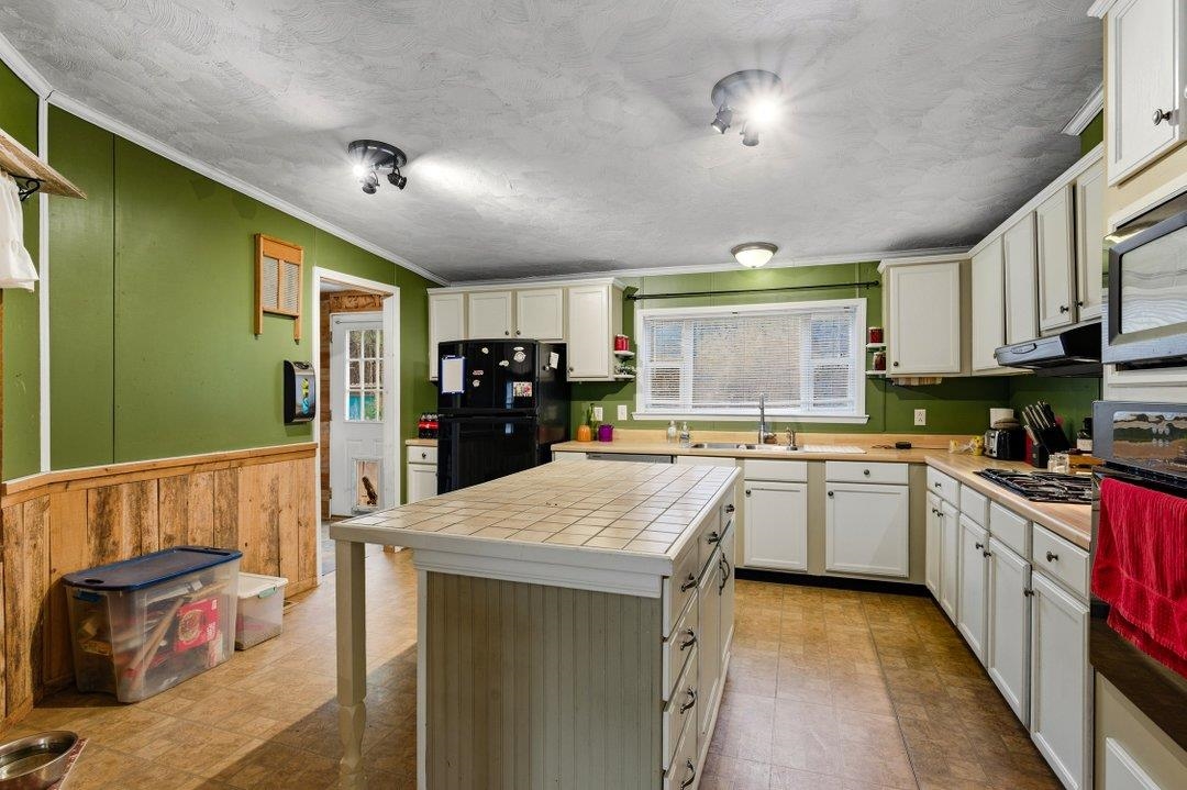 181 EV Road Loris, SC 29569 - Photo 12 of 33 Kitchen featuring tile countertops, crown molding, oven, freestanding refrigerator, and a textured ceiling