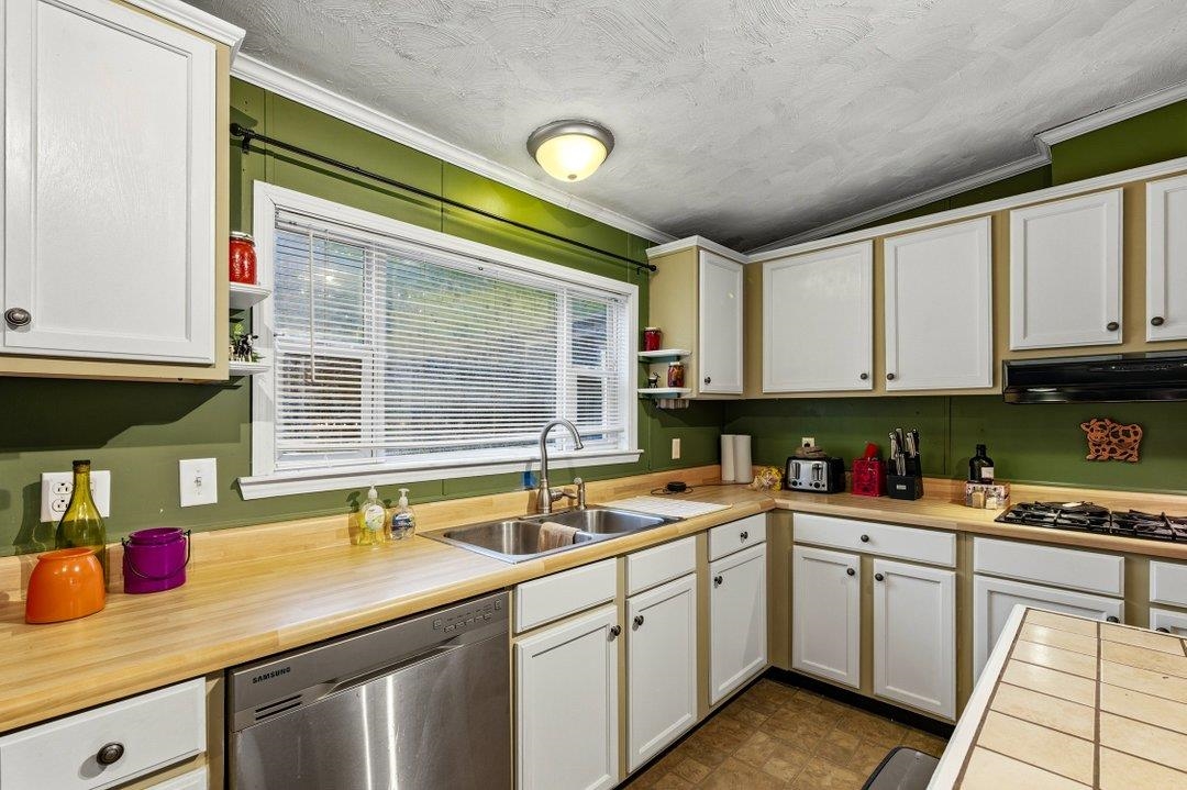 181 EV Road Loris, SC 29569 - Photo 15 of 33 Kitchen featuring ornamental molding, dishwasher, white cabinets, open shelves, and a textured ceiling