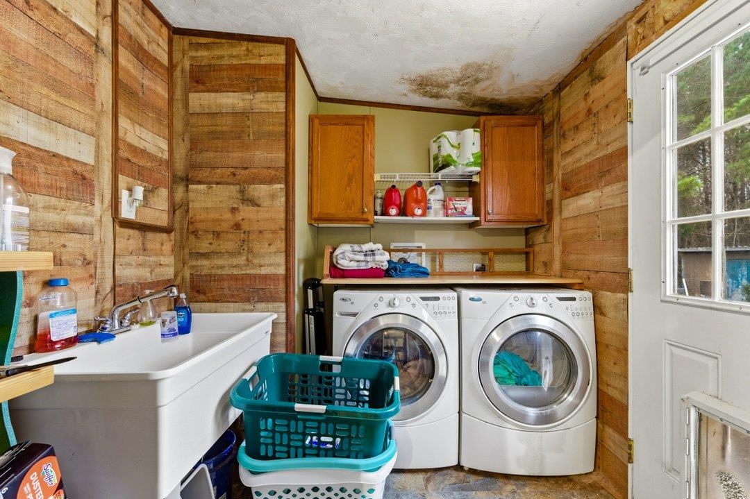 181 EV Road Loris, SC 29569 - Photo 17 of 33 Laundry area with wood walls, washer and clothes dryer, and cabinet space