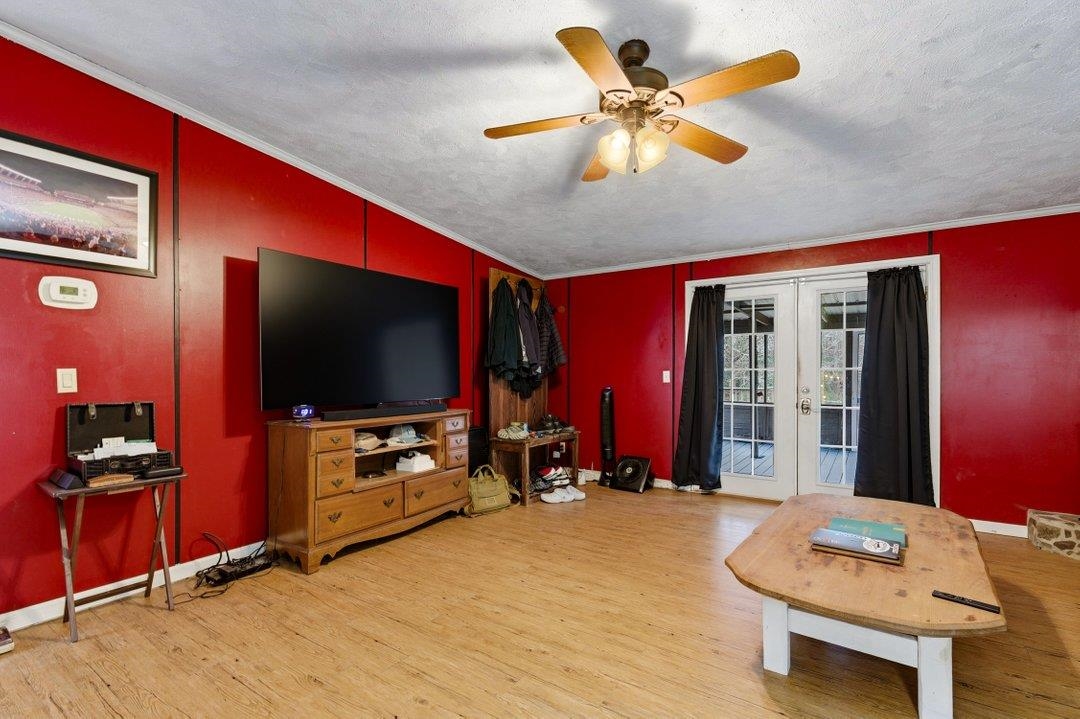 181 EV Road Loris, SC 29569 - Photo 19 of 33 Living area featuring french doors, ornamental molding, light wood-style flooring, a textured ceiling, and a ceiling fan