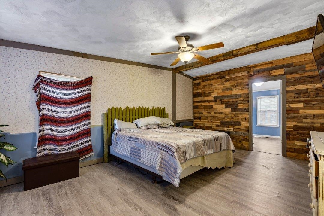 181 EV Road Loris, SC 29569 - Photo 24 of 33 Bedroom with a textured ceiling, wood finished floors, a ceiling fan, and wallpapered walls