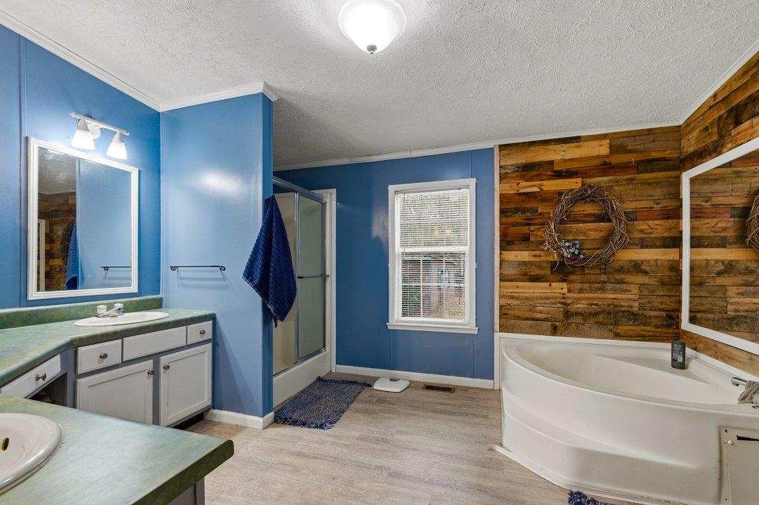 181 EV Road Loris, SC 29569 - Photo 26 of 33 Full bathroom featuring a garden tub, vanity, a textured ceiling, a shower with shower door, and light wood finished floors