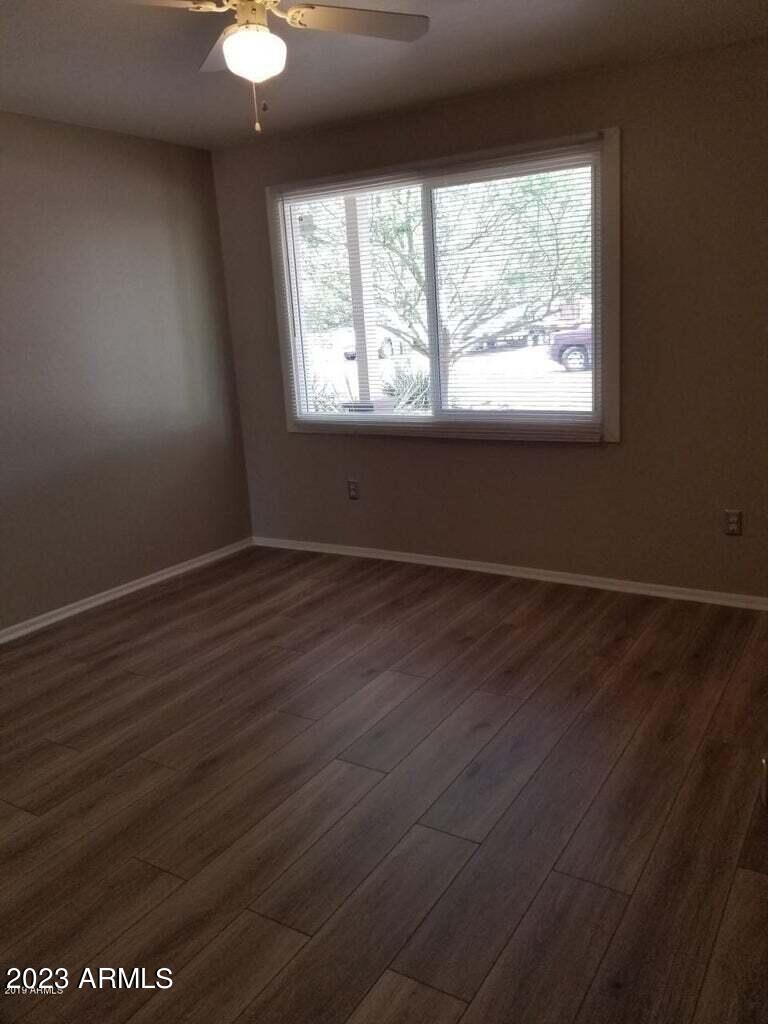 14420 North 39th Way Phoenix, AZ 85032 - Photo 9 of 24 an empty room with wooden floor and windows