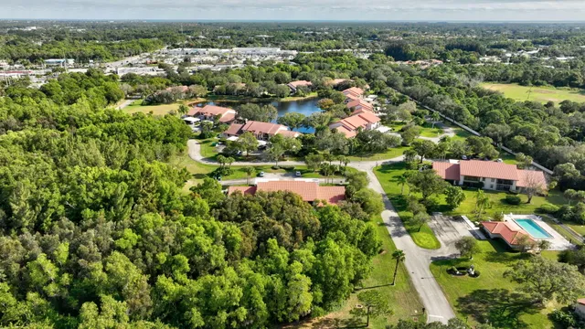 an aerial view of residential houses with outdoor space and trees