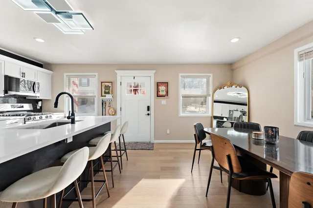 a kitchen with a sink stove and chairs