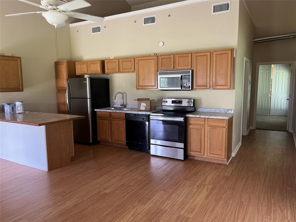 3841 Ledgestone Lane Midlothian, TX 76065 - Photo 5 of 26 a kitchen with stainless steel appliances kitchen island granite countertop a sink cabinets and wooden floor