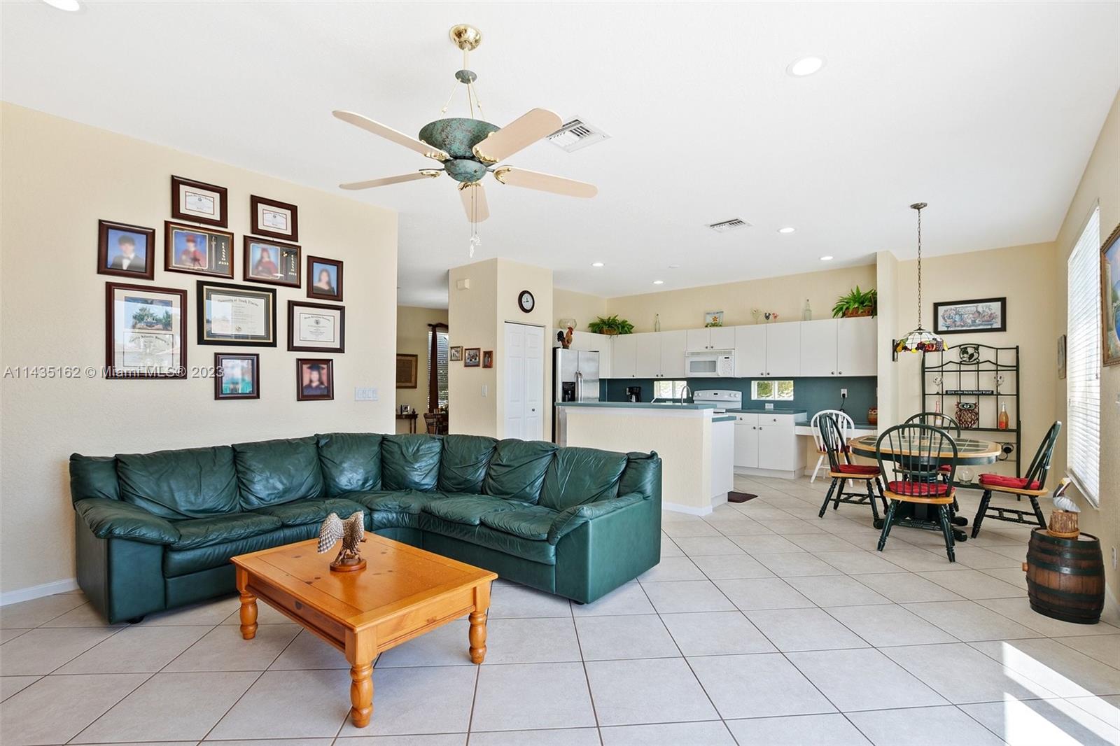 3165 Southwest 176th Way Miramar, FL 33029 - Photo 11 of 32 a living room with furniture a table and kitchen view