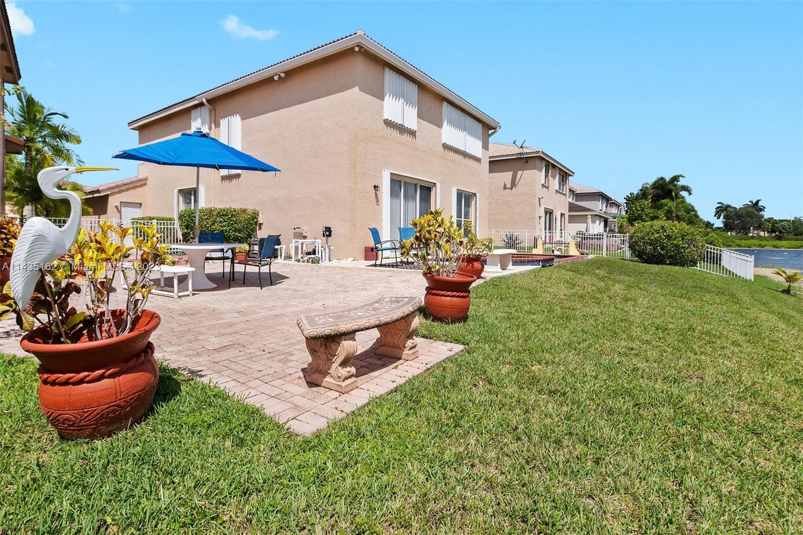 3165 Southwest 176th Way Miramar, FL 33029 - Photo 26 of 32 a view of a backyard with table and chairs under an umbrella