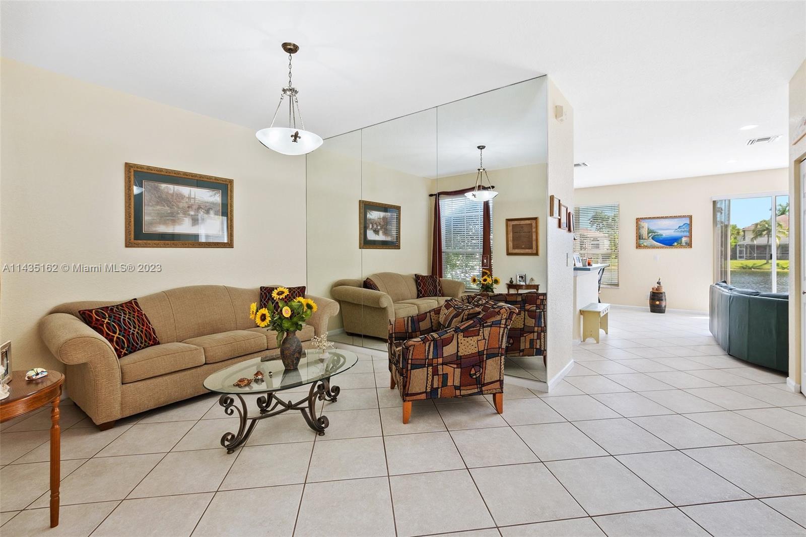 3165 Southwest 176th Way Miramar, FL 33029 - Photo 3 of 32 a living room with furniture a table and a chandelier