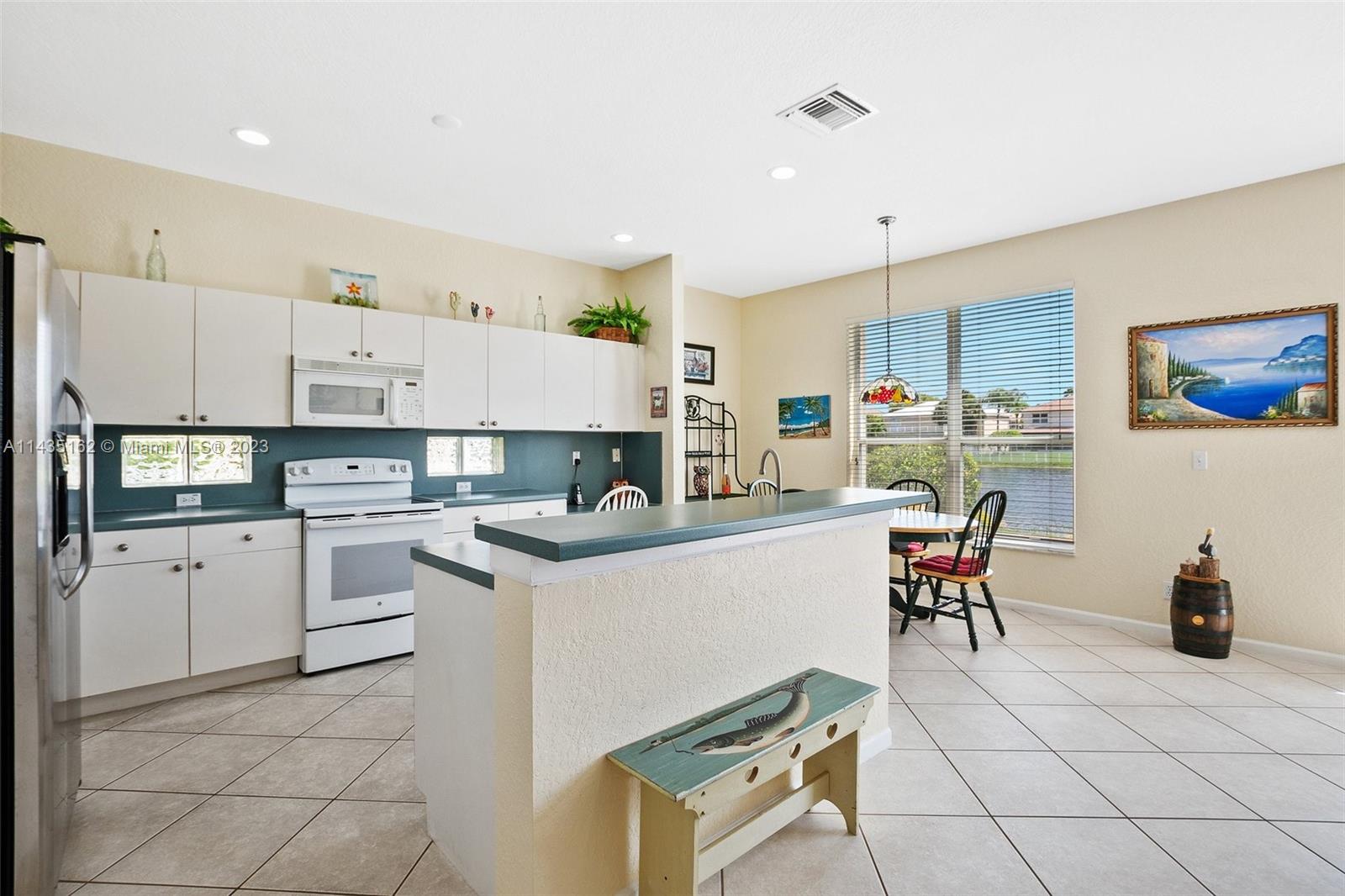 3165 Southwest 176th Way Miramar, FL 33029 - Photo 5 of 32 a kitchen with cabinets and chairs
