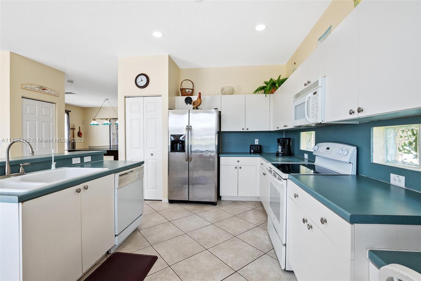 3165 Southwest 176th Way Miramar, FL 33029 - Photo 8 of 32 a kitchen with white cabinets and white appliances