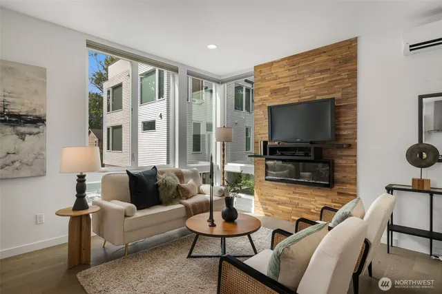 a living room with furniture a flat screen tv and a large window