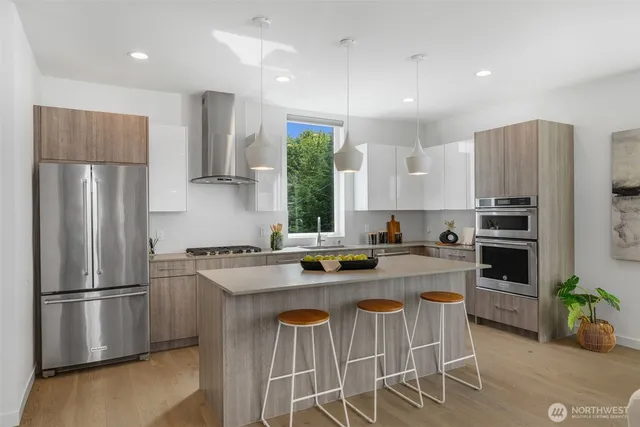 a kitchen with stainless steel appliances granite countertop a refrigerator a stove a sink and a refrigerator