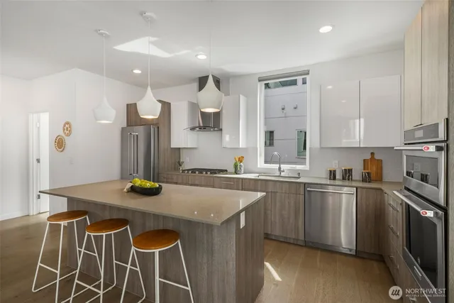 a kitchen that has a sink stainless steel appliances and cabinets