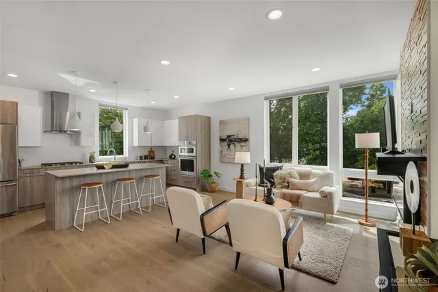 a kitchen with stainless steel appliances granite countertop a stove a sink a dining table and chairs