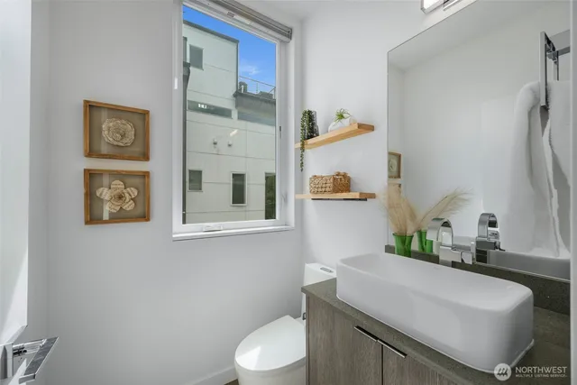 a bathroom with a sink mirror vanity and toilet