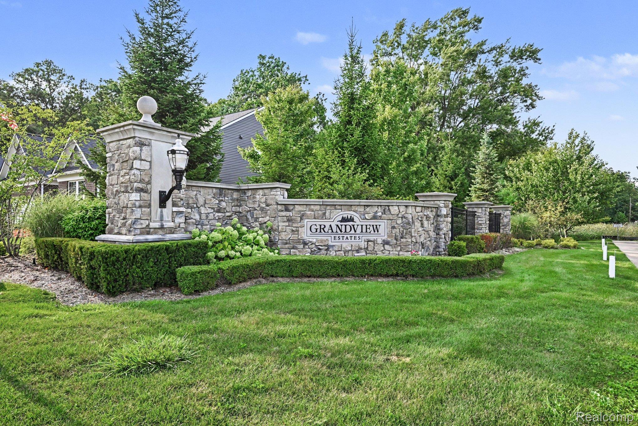 50153 Fowler Road Canton, MI 48188 - Photo 25 of 27 Stone entry monument with integrated lantern and manicured shrubbery