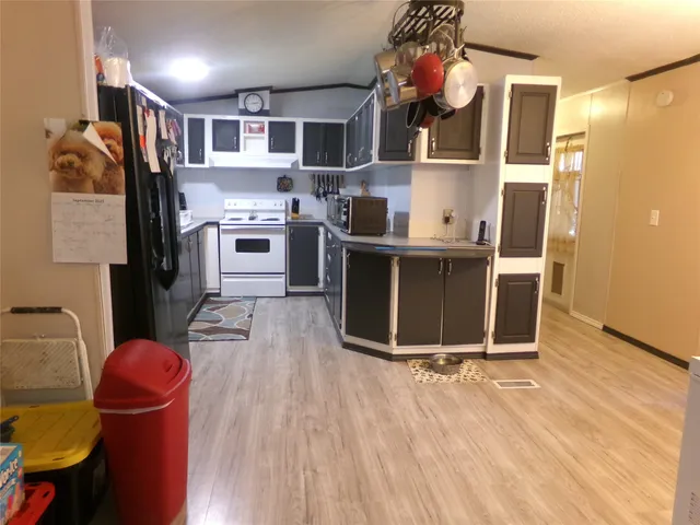 a kitchen with stainless steel appliances granite countertop a refrigerator a stove and a wooden floors