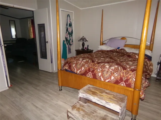 a bedroom with a bed and wooden floor