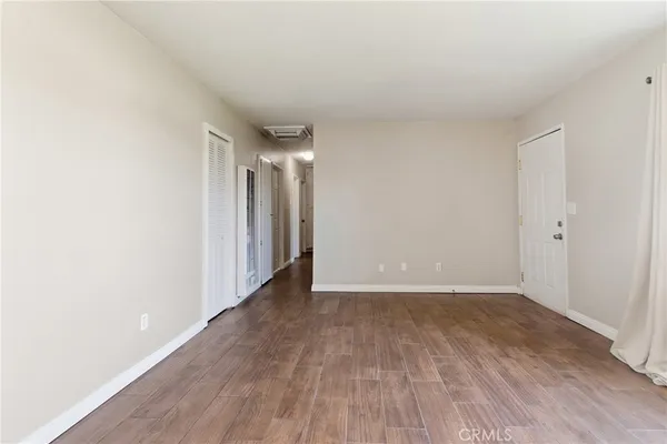 a view of an empty room with wooden floor