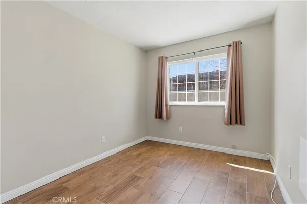 a view of an empty room with wooden floor