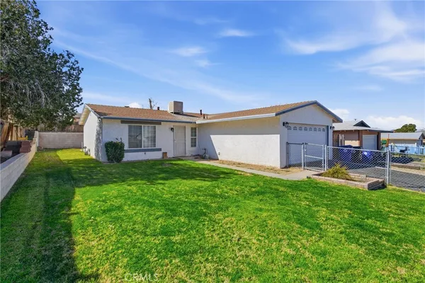a view of a house with a yard and sitting area