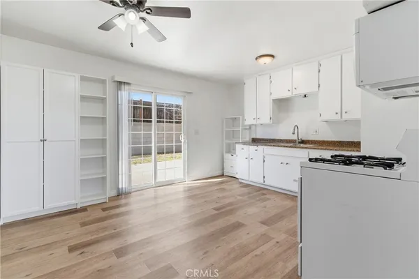 a large kitchen with stainless steel appliances granite countertop a stove a sink and a refrigerator with white cabinets