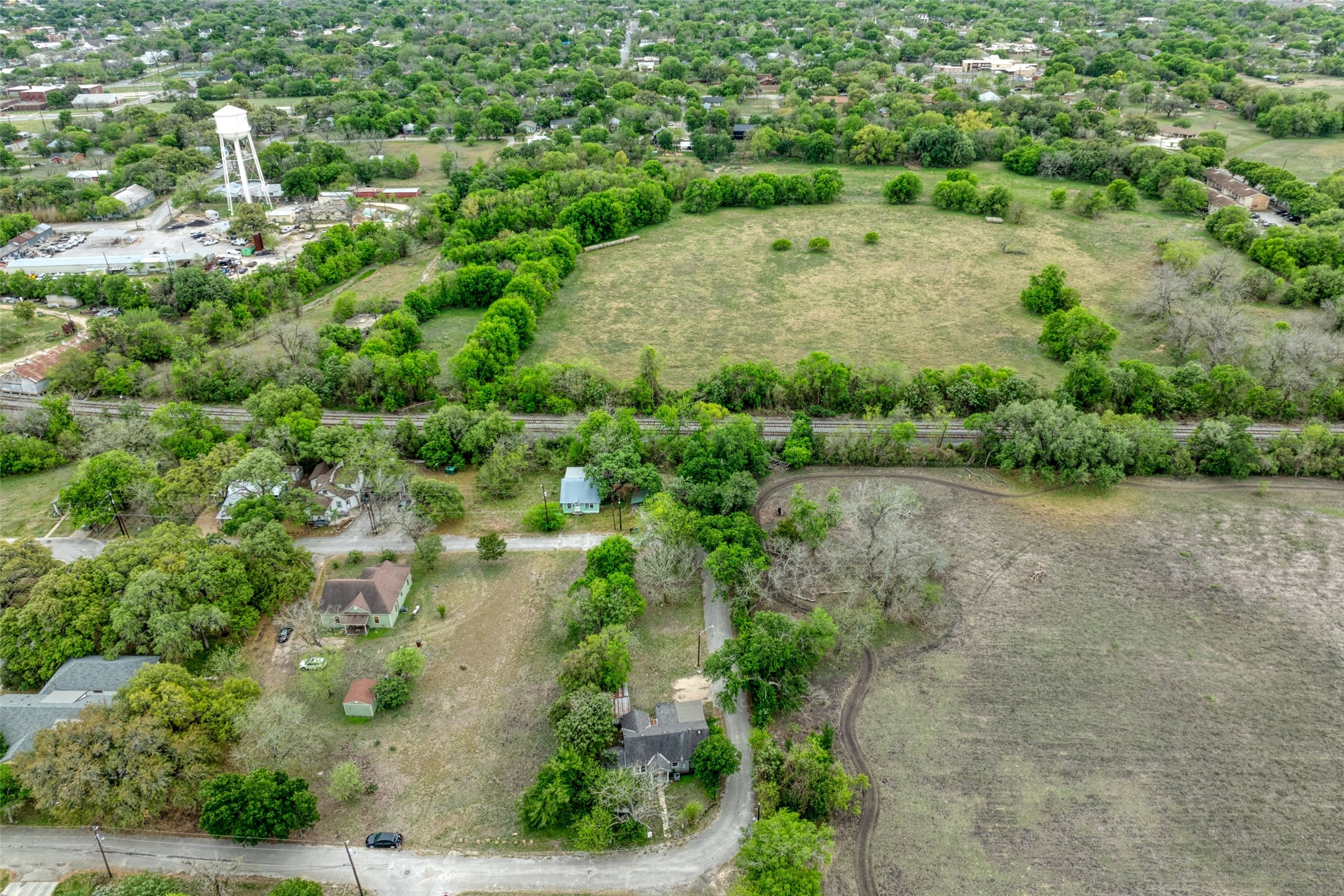 1002 Proctor Street Lockhart, TX 78644 - Photo 2 of 8 an aerial view of a house with a yard and lake view